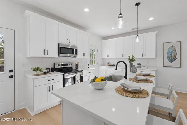 a kitchen with white cabinets and appliances