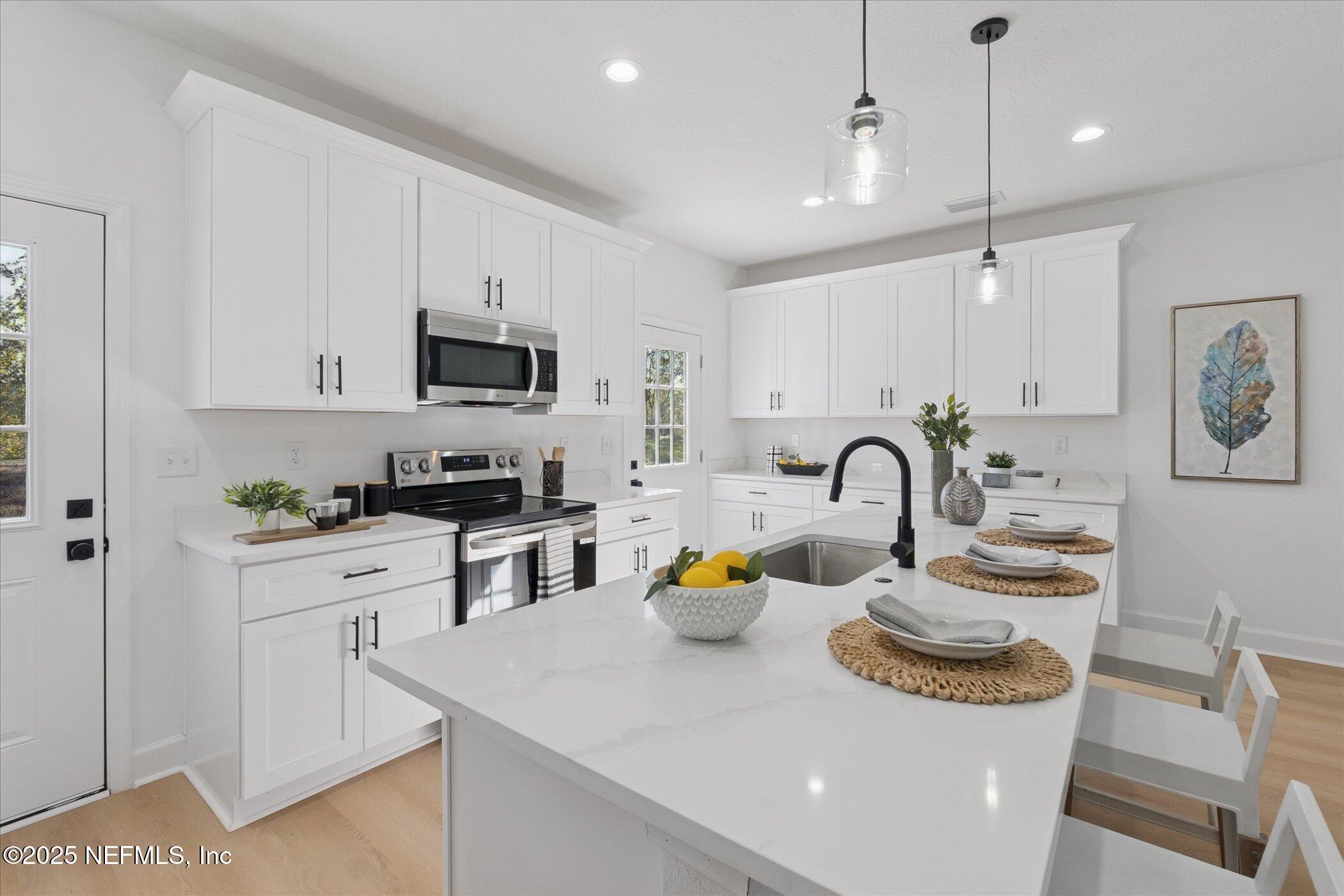 9293 Dolphin Street Sanderson, FL 32087 - Photo 8 of 29 a kitchen with white cabinets and appliances