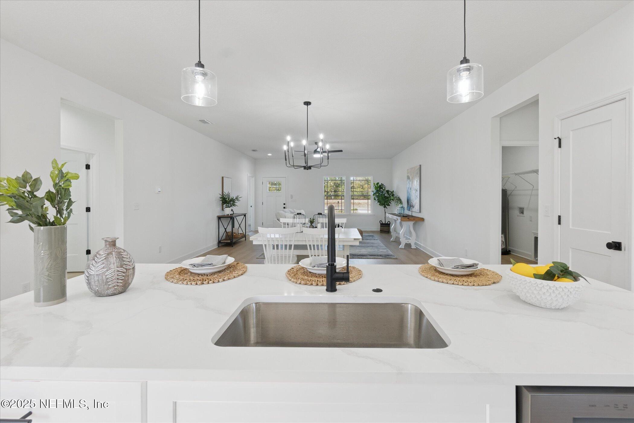 9293 Dolphin Street Sanderson, FL 32087 - Photo 9 of 29 a kitchen with a sink and chandelier