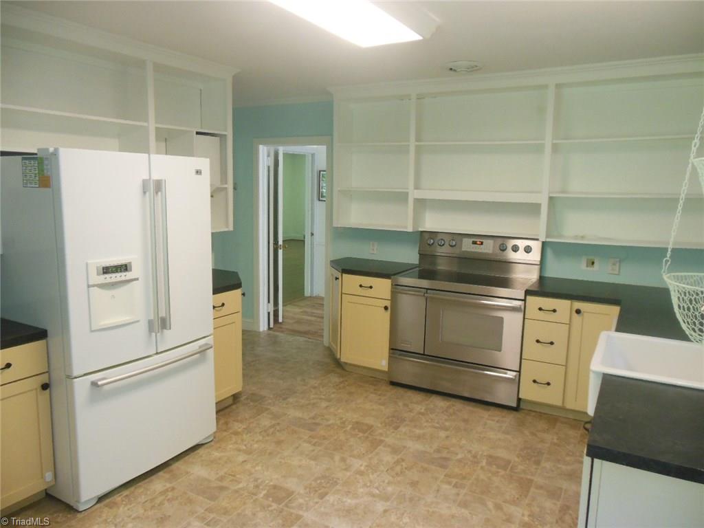 245 Country Club Road Mount Airy, NC 27030 - Photo 14 of 25 Part of kitchen with refrigerator and stove. Lots of cabinets and shelves.