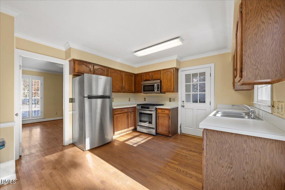 800 Temple Street Raleigh, NC 27609 - Photo 12 of 37 a kitchen with stainless steel appliances granite countertop a refrigerator sink and wooden cabinets