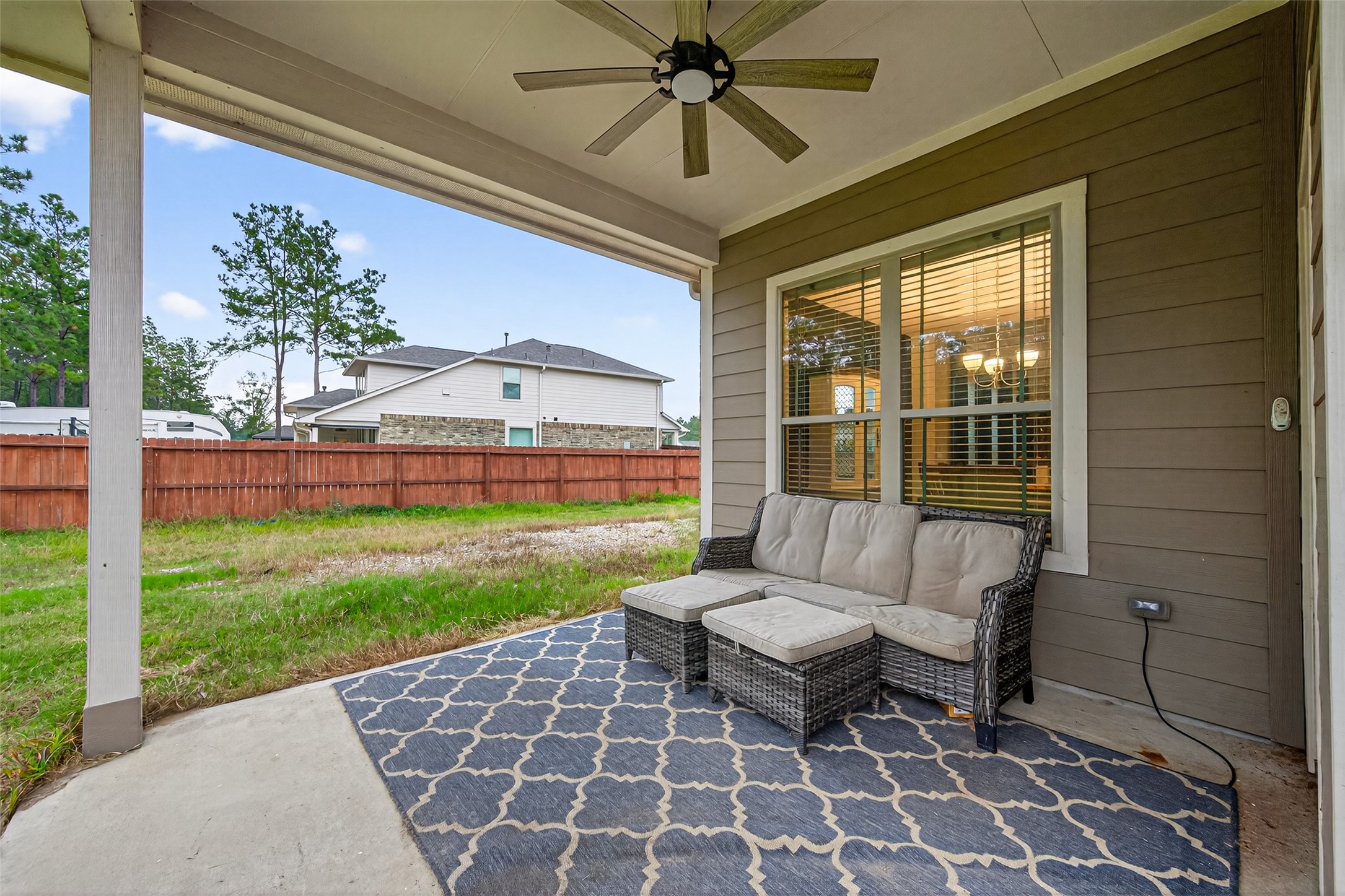16601 Crosby Street Conroe, TX 77303 - Photo 40 of 50 Relaxing covered patio with ceiling fan and room for outdoor seating—perfect for enjoying the backyard year-round.
