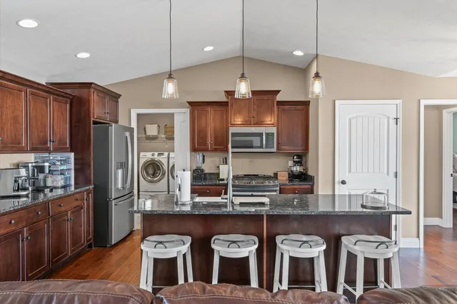a kitchen with stainless steel appliances granite countertop a stove a sink and a refrigerator