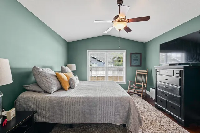 a bedroom with a bed a dresser and flat screen tv