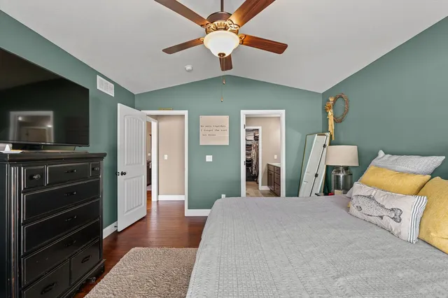 a bedroom with a bed and a flat tv screen on dresser