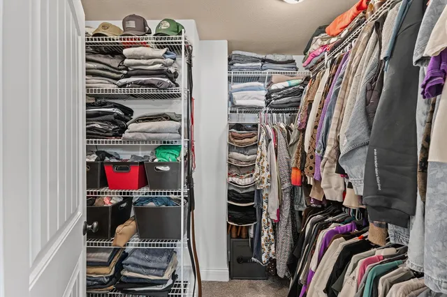 a view of walk in closet with clothes and shoes