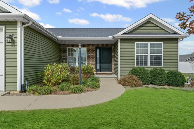 a front view of a house with a yard and potted plants