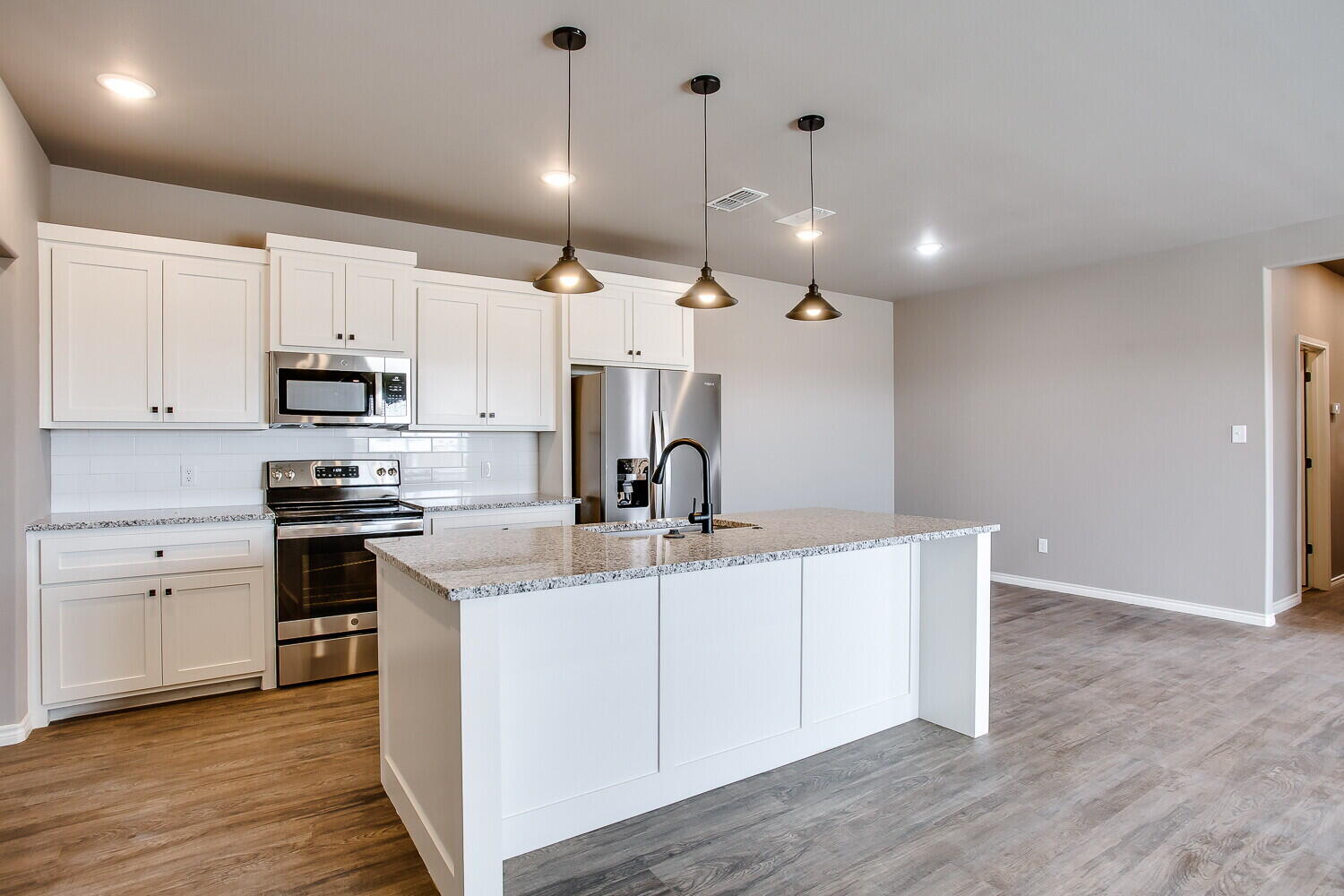 1405 16th Street, Unit A Shallowater, TX 79363 - Photo 8 of 17 a kitchen with kitchen island a sink stainless steel appliances and wooden floor