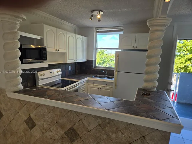 a kitchen with a sink a stove and a refrigerator
