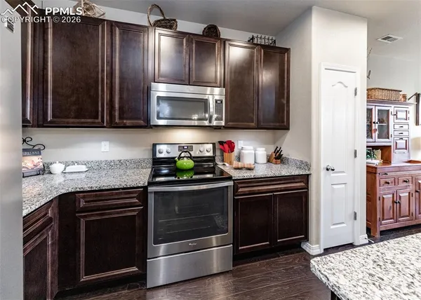 a kitchen with granite countertop stainless steel appliances and wooden cabinets