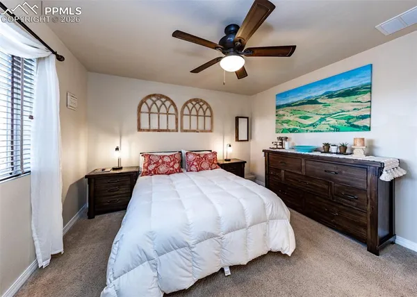 a bedroom with a bed and a large window