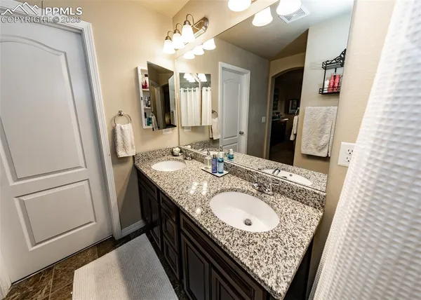 a bathroom with a granite countertop sink and a mirror