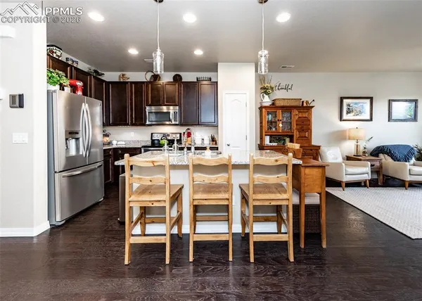a kitchen with refrigerator and chairs