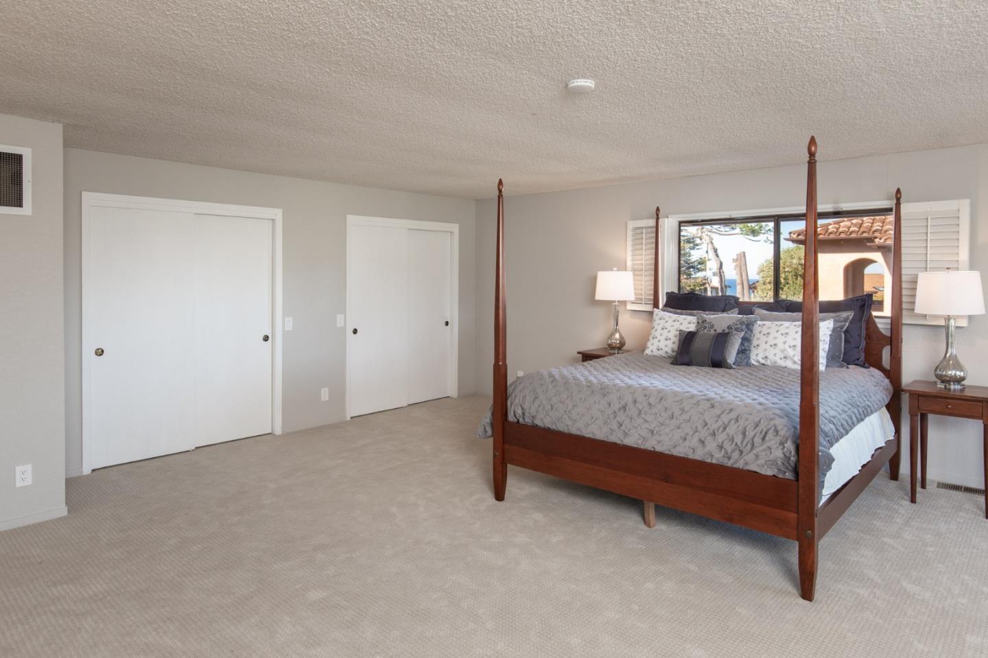 2972 Cormorant Road Pebble Beach, CA 93953 - Photo 19 of 26 a bedroom with a bed window and a mirror