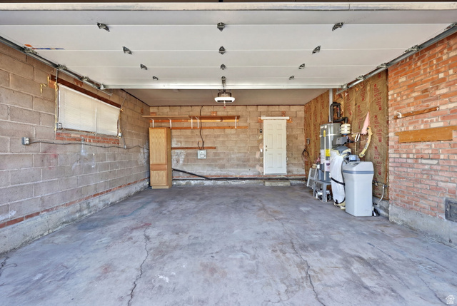 1180 North 400 East Bountiful, UT 84010 - Photo 32 of 50 Spacious garage with concrete block walls, exposed brick accents, and a concrete floor
