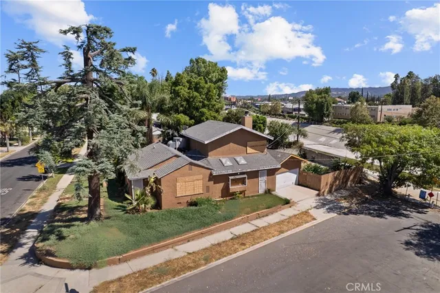 a view of a house with a yard and table and chairs under an umbrella