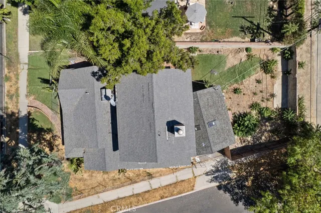an aerial view of a house with a yard and large trees
