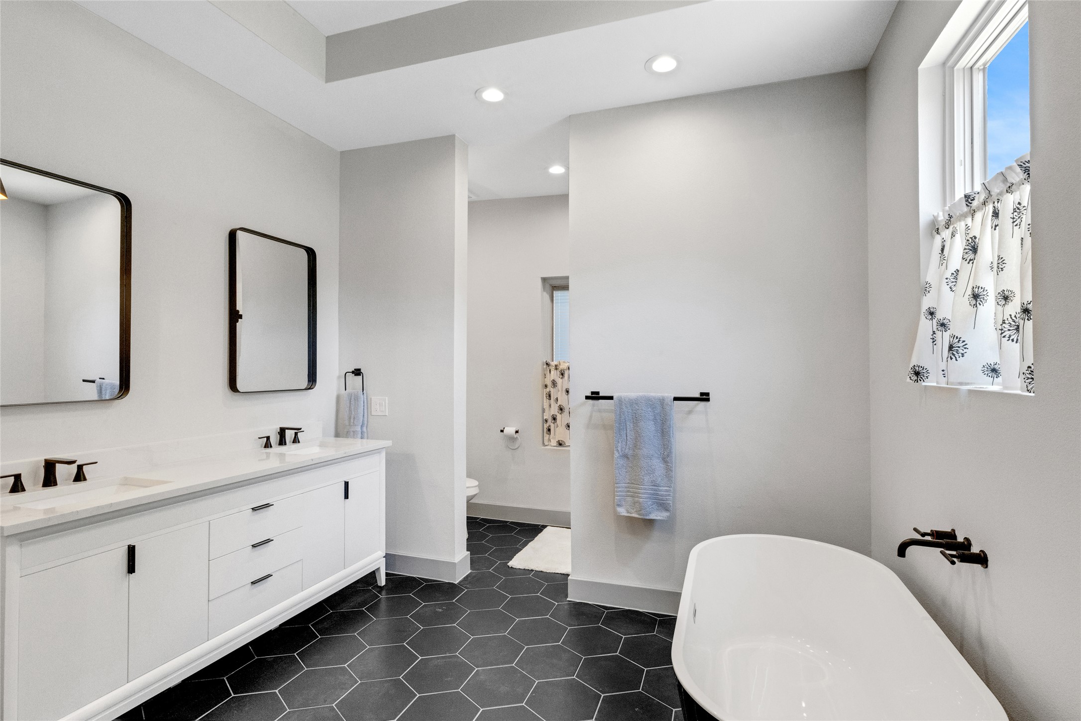 4227 Eck Lane Austin, TX 78734 - Photo 20 of 30 Full bath with a soaking tub, recessed lighting, double vanity, and dark tile patterned floors