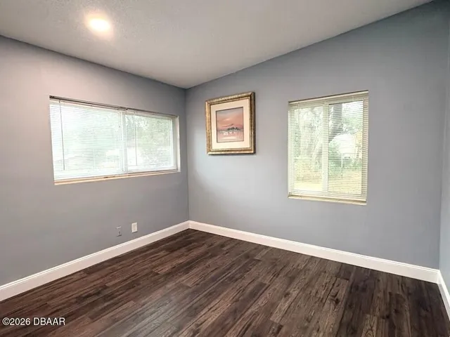 a view of a room with wooden floor and windows