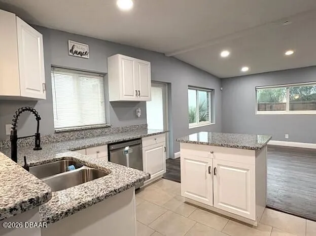 a kitchen with granite countertop a sink stove and cabinets
