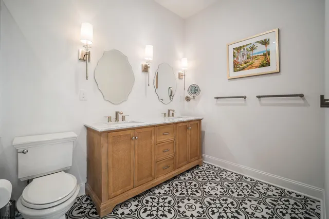 a bathroom with a toilet a sink a mirror a vanity and window