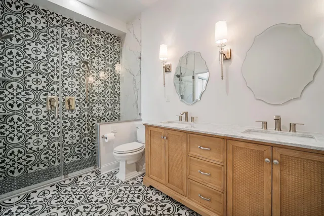 a bathroom with a double vanity sink mirror and toilet