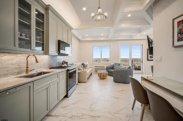 a large kitchen with a large counter top space a sink stainless steel appliances and cabinets