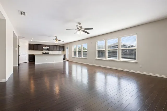 a view of empty room with wooden floor and fireplace