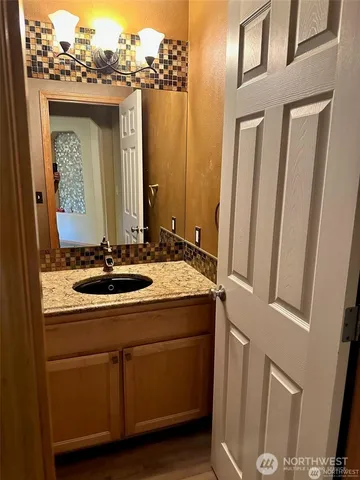 a bathroom with a granite countertop sink and a mirror