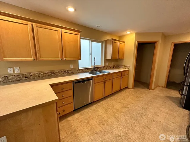 a kitchen with stainless steel appliances granite countertop a sink a stove and a refrigerator