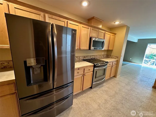 a kitchen with stainless steel appliances a refrigerator stove and microwave