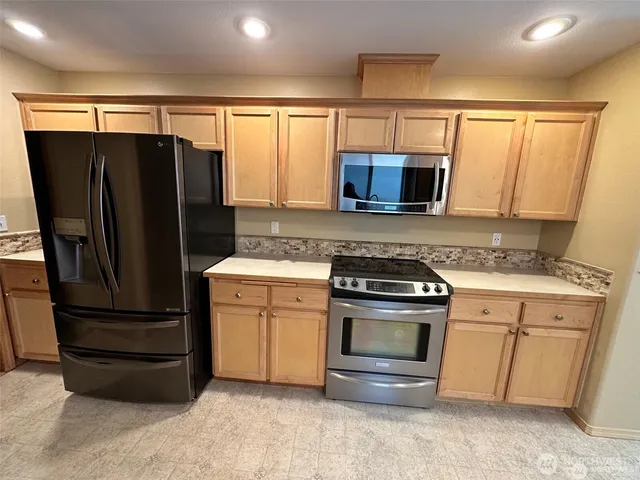 a kitchen with a refrigerator stove and microwave
