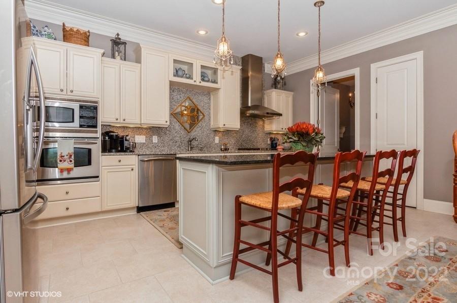 9517 Wheatfield Road Charlotte, NC 28277 - Photo 11 of 41 a kitchen with stainless steel appliances kitchen island granite countertop a table chairs sink and cabinets