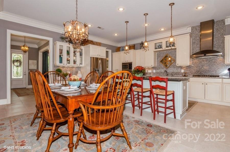 9517 Wheatfield Road Charlotte, NC 28277 - Photo 13 of 41 a dining room filled chandelier and kitchen view