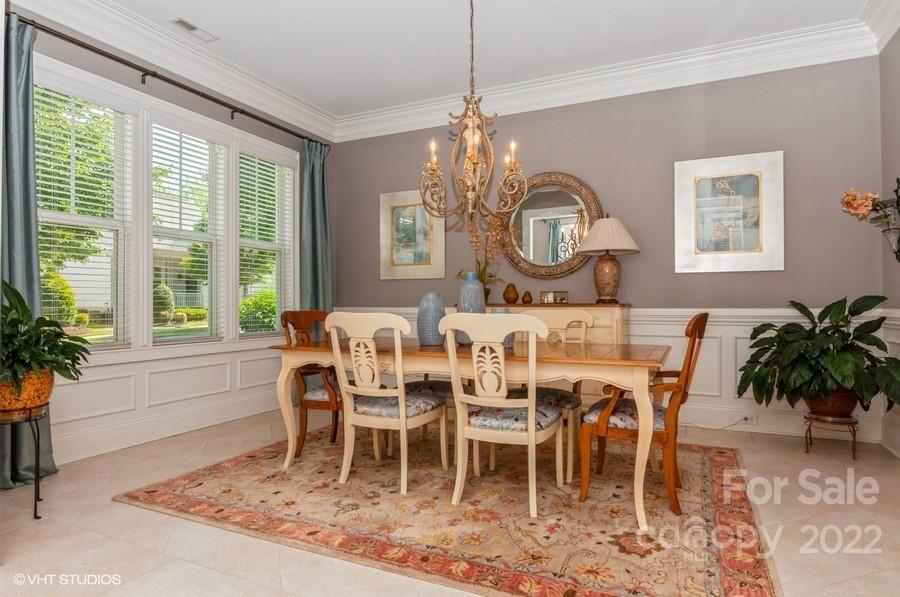 9517 Wheatfield Road Charlotte, NC 28277 - Photo 14 of 41 a dining room with wooden floor a chandelier a wooden table and chairs