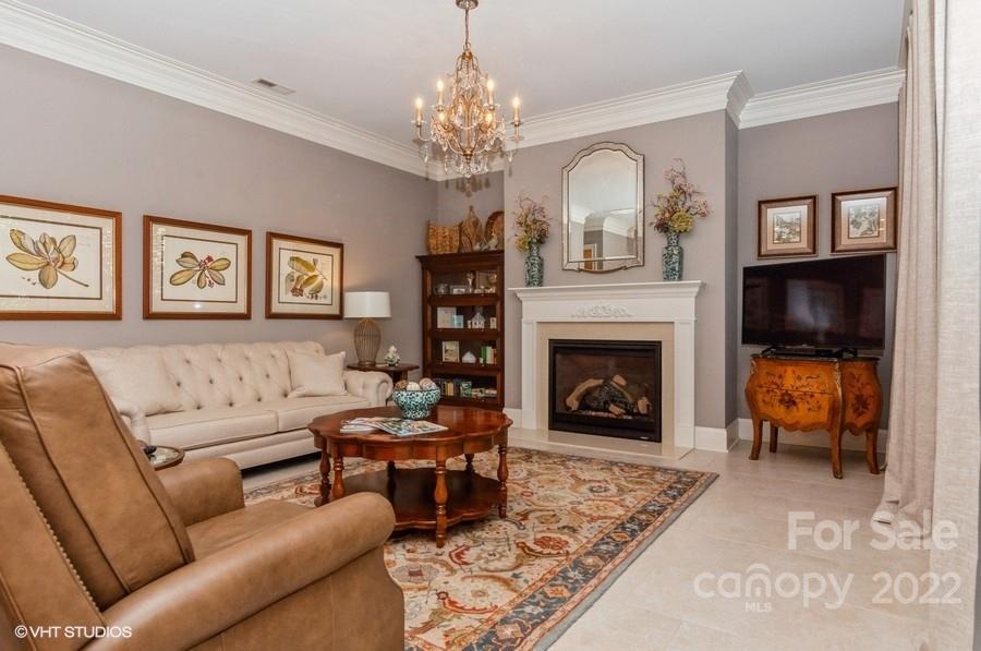 9517 Wheatfield Road Charlotte, NC 28277 - Photo 16 of 41 a living room with furniture a fireplace and a chandelier