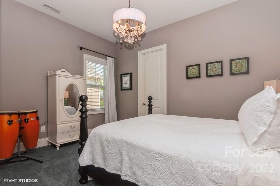 9517 Wheatfield Road Charlotte, NC 28277 - Photo 30 of 41 a bedroom with a large bed and a chandelier