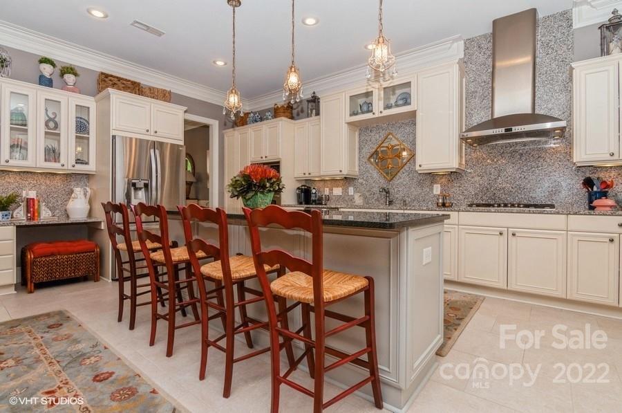 9517 Wheatfield Road Charlotte, NC 28277 - Photo 9 of 41 a kitchen with stainless steel appliances kitchen island granite countertop a table chairs sink and cabinets