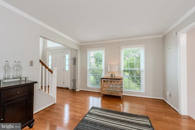 a view of a livingroom with furniture hardwood floor and workspace