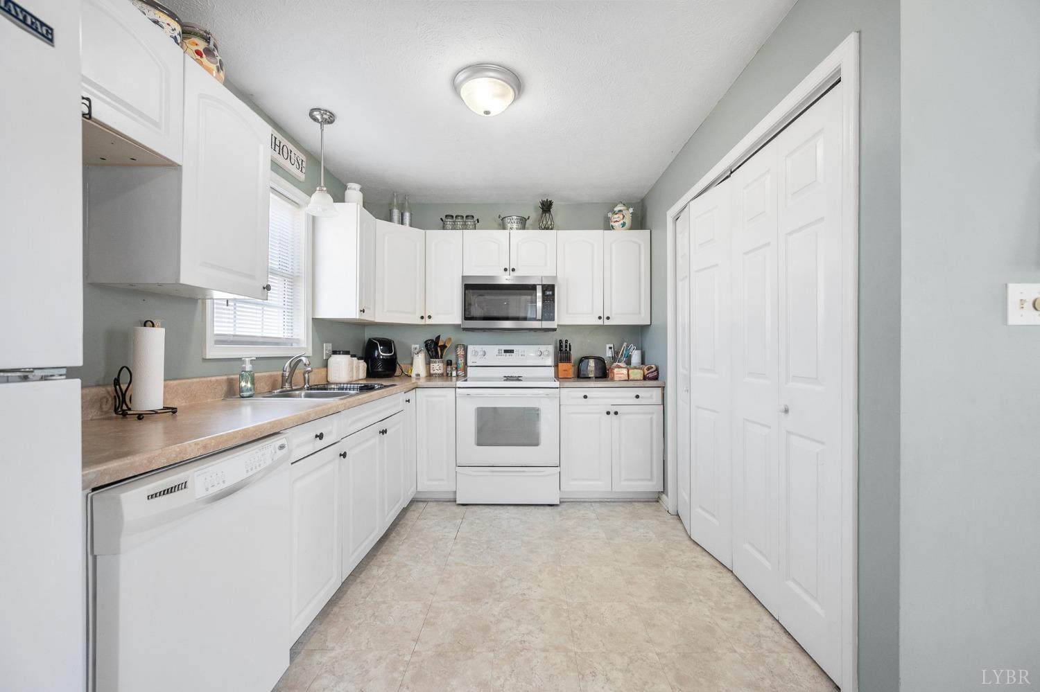 360 Webster Drive Concord, VA 24538 - Photo 12 of 36 a kitchen with white cabinets and white appliances