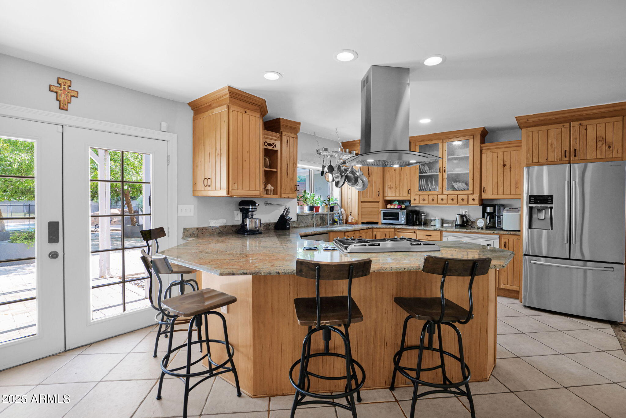 3217 East Flower Street Phoenix, AZ 85018 - Photo 18 of 60 a kitchen with stainless steel appliances a dining table chairs refrigerator and sink