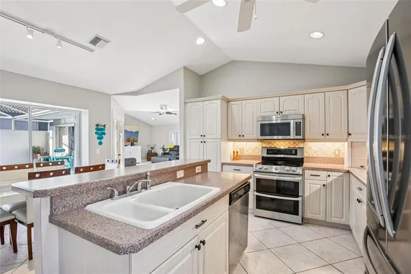 a kitchen with stainless steel appliances granite countertop a sink stove microwave and refrigerator