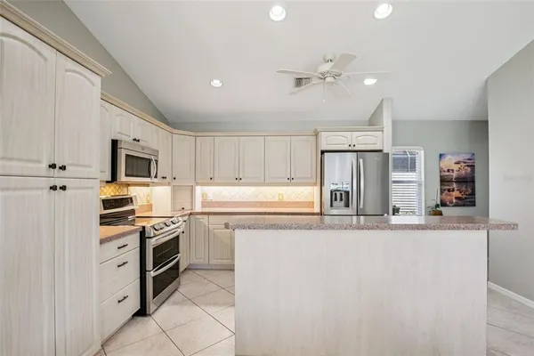 a kitchen with stainless steel appliances granite countertop a refrigerator and a stove top oven