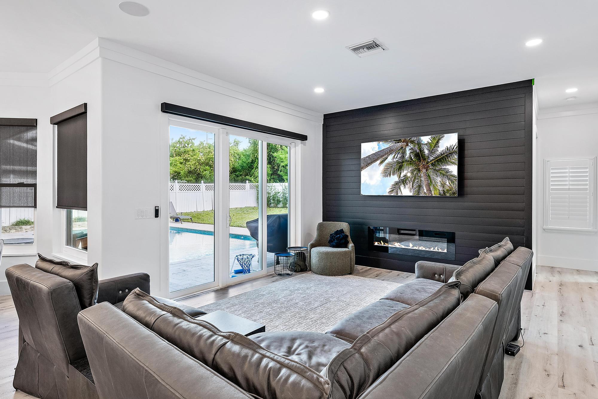 596 North Cypress Drive Tequesta, FL 33469 - Photo 14 of 28 a living room with furniture a floor to ceiling window and a flat screen tv