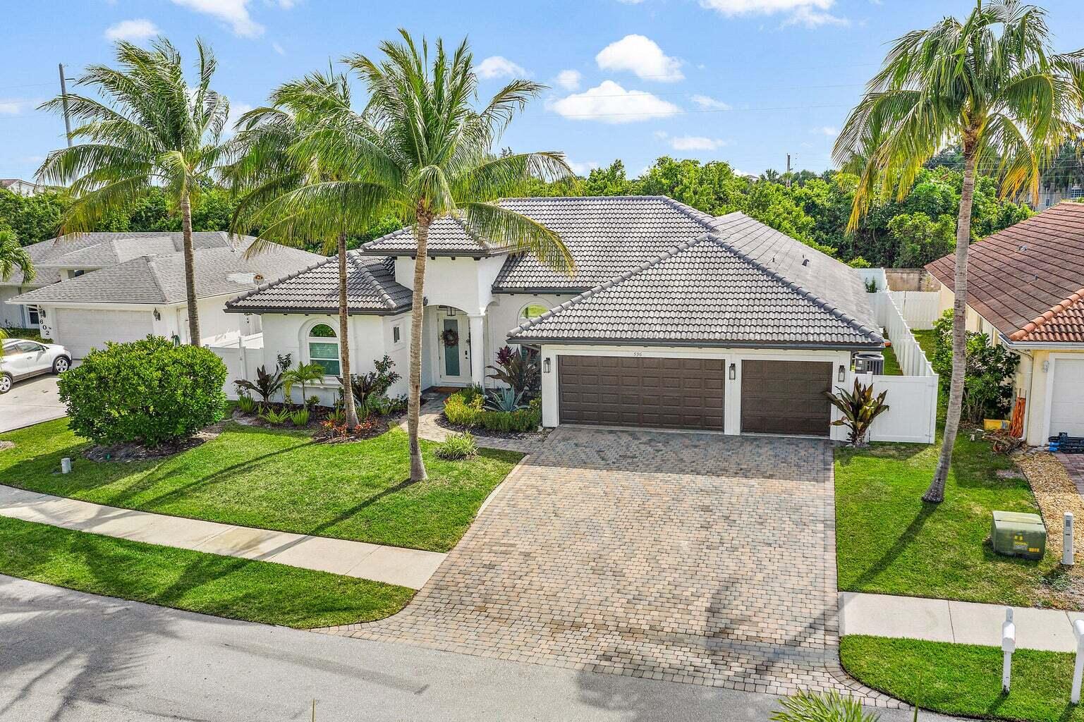 596 North Cypress Drive Tequesta, FL 33469 - Photo 2 of 28 a front view of house with yard and green space