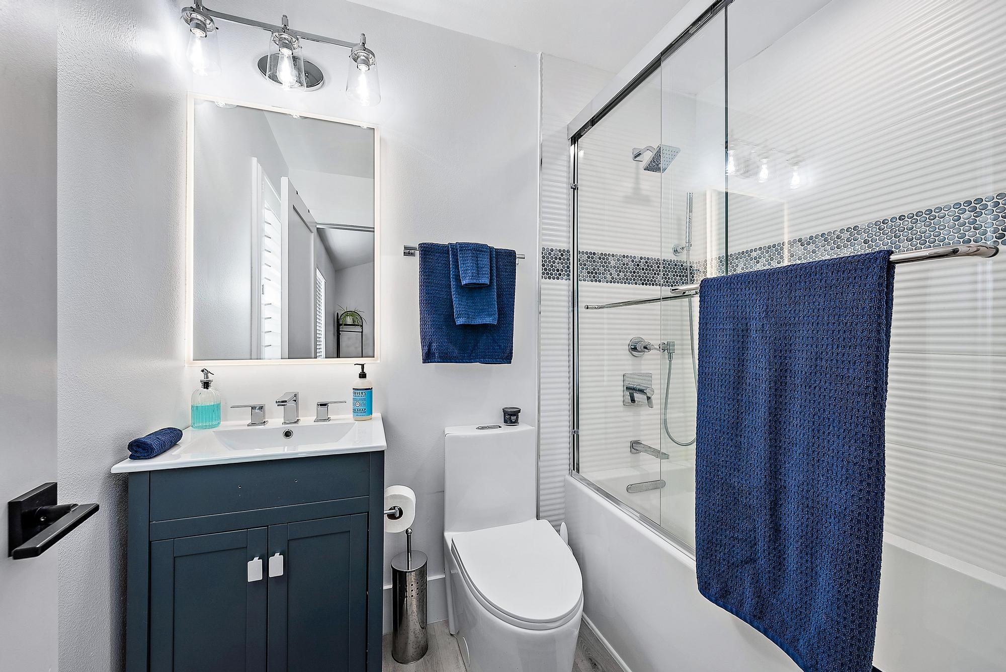 596 North Cypress Drive Tequesta, FL 33469 - Photo 24 of 28 a bathroom with a sink a toilet a mirror a vanity and shower