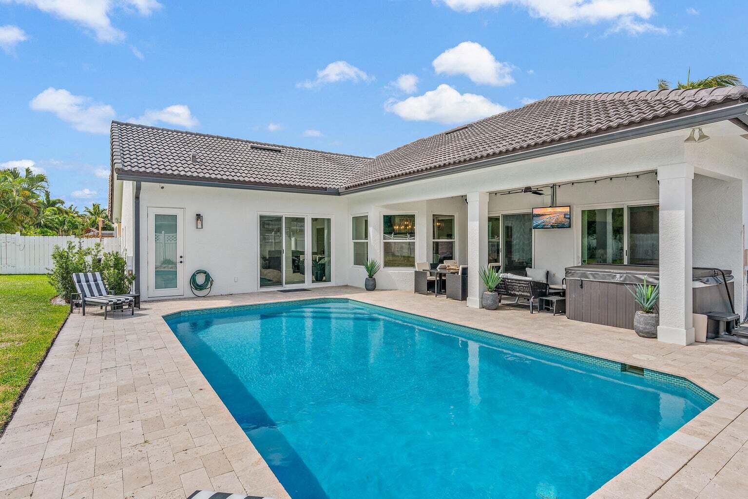 596 North Cypress Drive Tequesta, FL 33469 - Photo 3 of 28 a view of a house with swimming pool and furniture