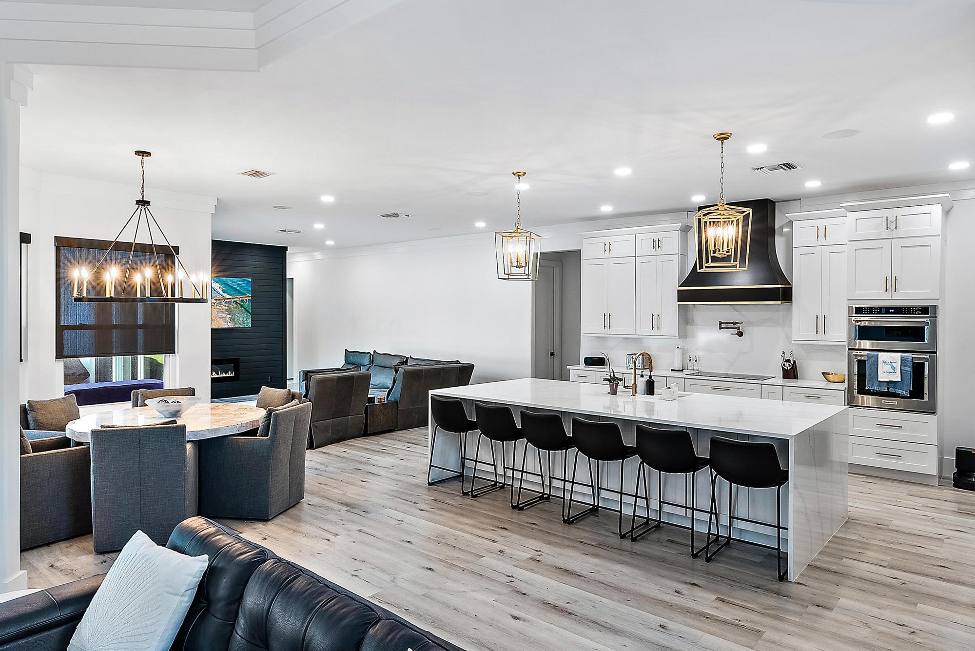 596 North Cypress Drive Tequesta, FL 33469 - Photo 9 of 28 a kitchen with stainless steel appliances kitchen island granite countertop a sink dishwasher a dining table and chairs with wooden floor