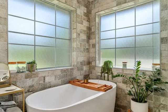 a bath tub sitting next to a white toilet and a shower