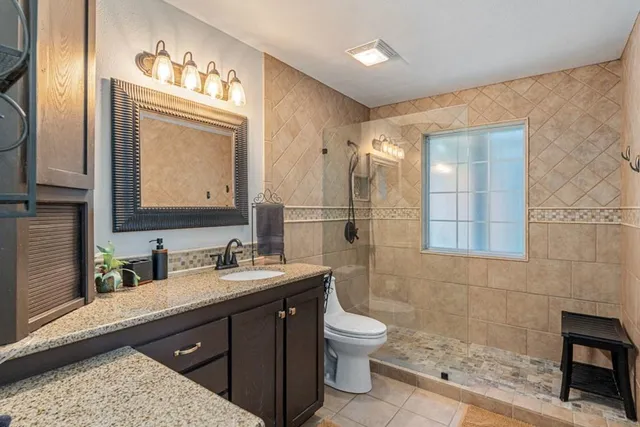 a bathroom with a double vanity sink toilet and mirror